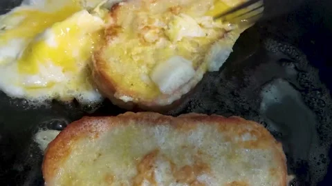 Bread with egg fried in boiling oil in a frying pan Stock Footage 197791977