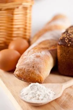 Bread, flour, eggs and kitchen utensil Stock Photos