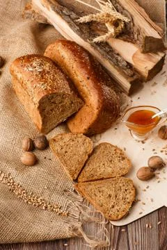 Bread in form of triangle and with nuts and honey near spikelets of wheat lie Stock Photos