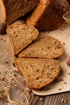 Bread in form of triangle and with nuts and honey near spikelets of wheat lie Stock Photos
