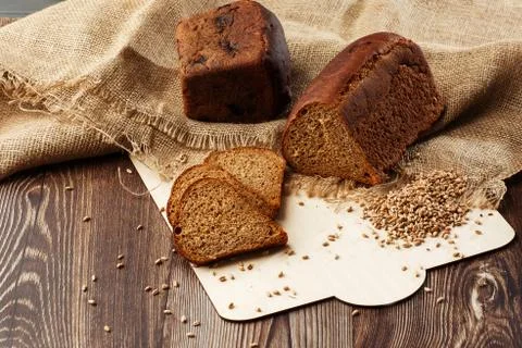 Bread in form of triangle and with sunflower seeds near spikelets of wheat li Stock Photos