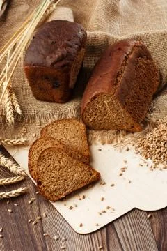 Bread in form of triangle and with sunflower seeds near spikelets of wheat li Stock Photos