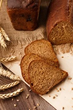 Bread in form of triangle and with sunflower seeds near spikelets of wheat li Stock Photos
