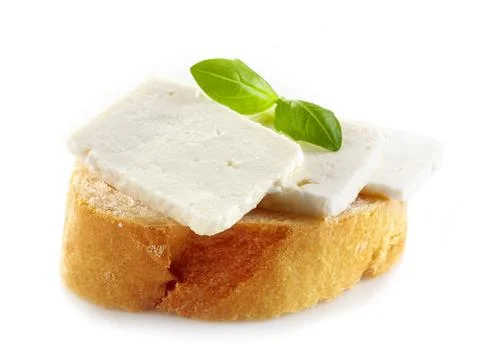 Bread with fresh goat cheese and basil on a white background Stock Photos