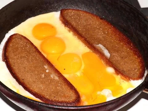 Bread is fried in an egg Stock Photos