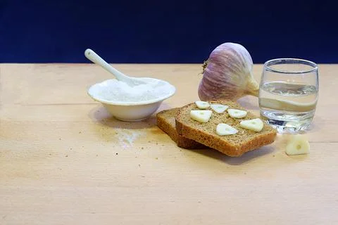 Bread, garlic, salt, vodka on the table. Stock Photos