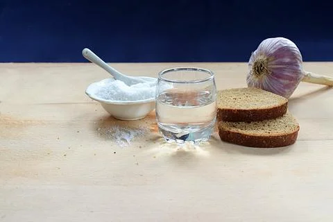 Bread, garlic, salt, vodka on the table. Stock Photos