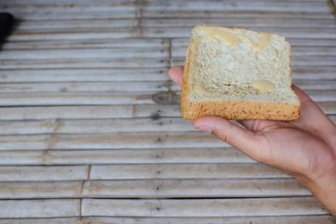 Bread in hand in hand on bamboo background. Stock-Fotos