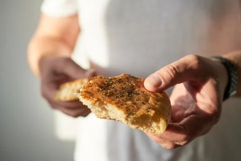 Bread in hands of a man on a gray background. Selective focus. Stock Photos
