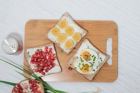 Bread has cream cheese and pomegranate boiled egg banana on white background. Stock Photos