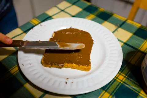 Bread with hazelnut cream and chocolate spread with knife on the kitchen tabl Stock Photos