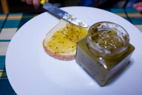 Bread with kiwi jam spread with knife on the kitchen table Stock Photos