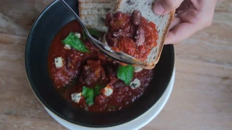 On the bread lay out a dish of healthy nutritious red beans prepared in tomato Stock Footage 182780071