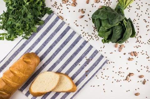 Bread with linseed, greenery on kitchen towel. Stock Photos