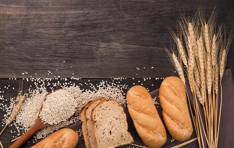 Bread loaves and sliced ??bread with wheat seeds put on a dark chalkboard On  Stock Photos
