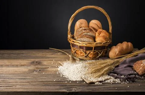 Bread loaves and sliced ??bread with wheat seeds placed on a dark brown woode Stock Photos