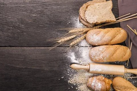 Bread loaves and sliced ??bread with wheat seeds put on a dark chalkboard On  Stock Photos