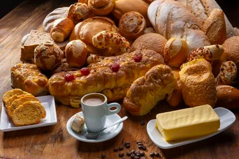 Bread with melted butter, various artisan breads and a cup of espresso on a w Stock Photos