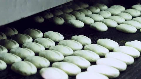 Bread moving on a conveyor belt, ready for baking in bakery Stock Footage 70749450