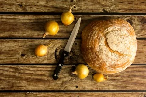 Bread, onion, knife on the table. View from above Stock Photos