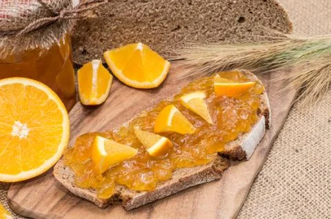 Bread with orange jam (rustic background) Stock Photos