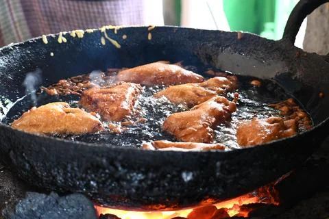 Bread pakora is being fried in hot oil. Stock Photos