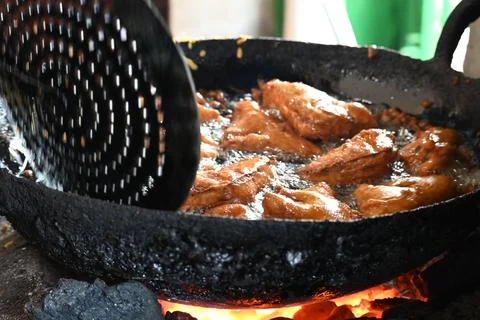 Bread pakora is being fried in hot oil. Stock Photos