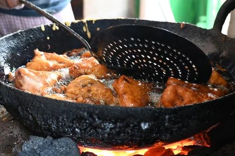 Bread pakora is being fried in hot oil. Stock Photos