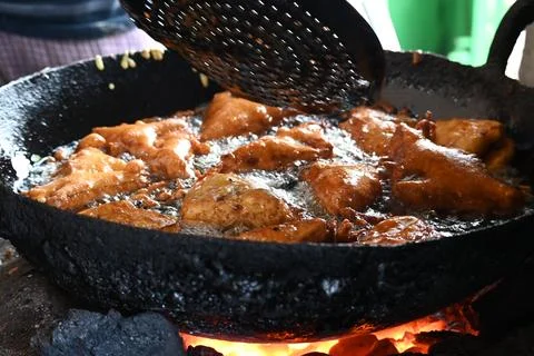 Bread pakora is being fried in hot oil. Stock Photos