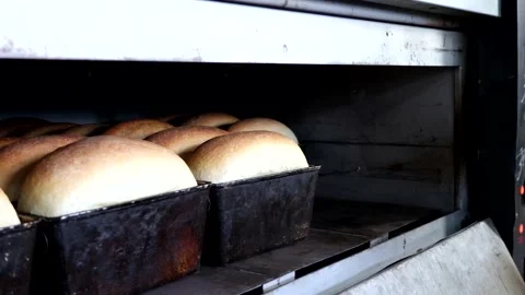 Bread pans are swapped in the oven for even cooking. Stock Footage 180454442
