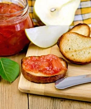 Bread with pear jam and leaf on board Stock Photos