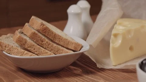 Bread, piece of cheese, and olives in a white bowls Stock Footage 73918995