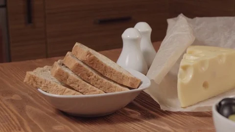 Bread, piece of cheese, and olives in a white bowls Stock Footage 73919006