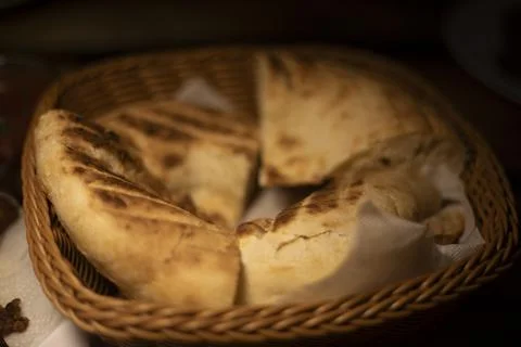Bread on a plate. Baked bread on a wicker plate. Warm baked goods. Stock Photos