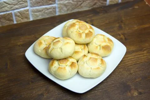 Bread on a plate on a wooden table seen from above Stock Photos