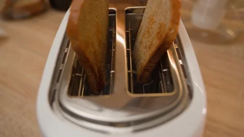Bread pops out of the toaster and hands pick it up. Making toast, close-up 스톡 동영상 324517934