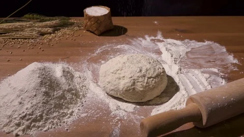 Bread is poured with flour using a sieve Stock Footage 76404965