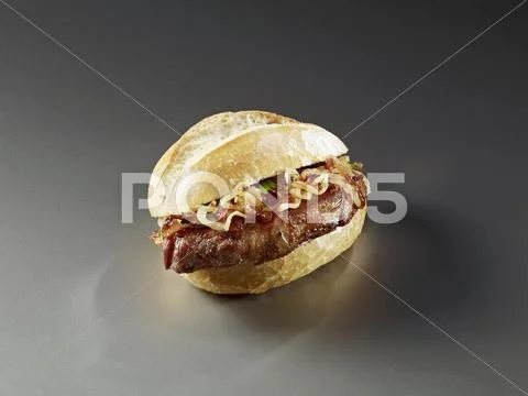 A bread roll filled with beef and onions Stock Photos