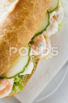 Bread roll filled with shrimps, cucumber and remoulade Stock Photos