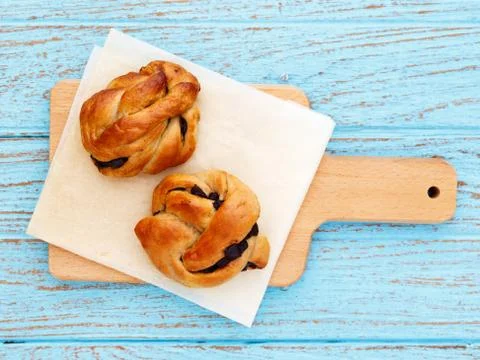 Bread roll pastry on baking paper on wood table Stock Photos