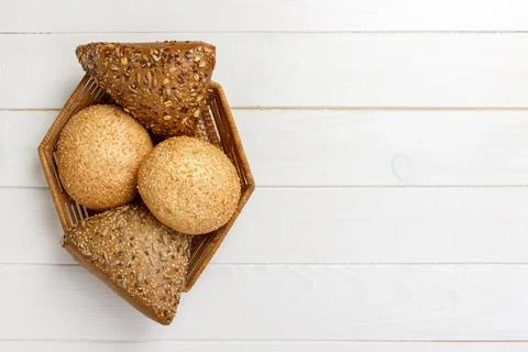 Bread rolls in the basket on rustic wooden background Foto stock