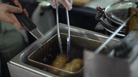 Bread rolls deep fried in vat of boiling hot oil, filmed as close up shot Stock Footage 248202296