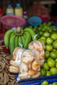 Bread rolls packaged beside bananas and limes at market Stock Photos