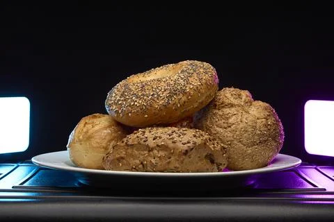 Bread rolls variety on plate with dramatic light and dark background Stock Photos
