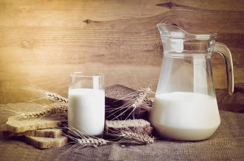 Bread from rye and wheat flour of rough grinding and glass of fresh cow's mil Stock Photos