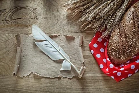Bread rye ears red dotted napkin quill vintage scroll on wooden board Stock Photos