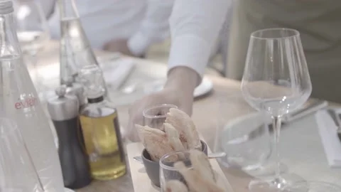 Bread is served at the table in the garden of a chic restaurant in France Stock Footage 135398488