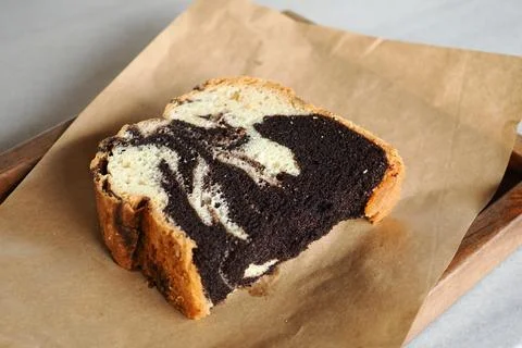 Bread slice with chocolate and vanilla swirl on table Stock Photos