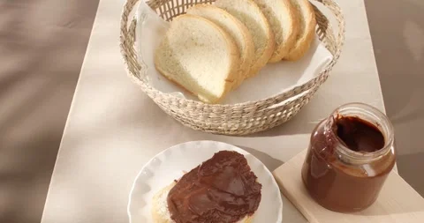 Bread slice with chocolate hazelnut spread or butter. High Angle view. Stock Footage 242506552