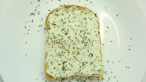 Bread slice with cream cheese and herb in white plate Stock Footage 76102545